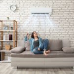 Women sitting on a couch enjoying her air conditioning system